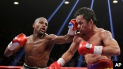 Floyd Mayweather Jr., left, hits Manny Pacquiao, from the Philippines, during their welterweight title fight in Las Vegas, Nevada, May 2, 2015.