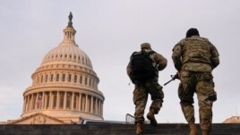 National Guard members walk at the Capitol, in Washington, U.S., January 15, 2021. REUTERS/Joshua Roberts