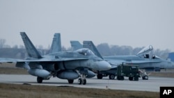 File - In this Nov. 19, 2014, photo, a Canada CF-188 Hornet jet fighter prepares for take off during NATO drills near Vilnius, Lithuania. Canada announced on June 7, 2017, a plan to increase military spending that includes the purchase of 88 fighter jets.