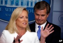 FBI Director Christopher Wray listens as Secretary of Homeland Security Kirstjen Nielsen speaks during the daily press briefing at the White House, Aug. 2, 2018, in Washington.