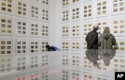 FILE - People stand in front of 372 drawings with the title '1912-60s' of German artist Korbinian Aigner during the press preview of the dOCUMENTA (13)in Kassel, Germany, June 6, 2012.