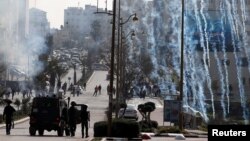 Israeli forces fire tear gas canisters at Palestinian protesters during clashes near the Jewish settlement of Beit El, in the Israeli-occupied West Bank March 20, 2019. 
