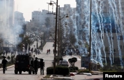 Israeli forces fire tear gas canisters at Palestinian protesters during clashes near the Jewish settlement of Beit El, in the Israeli-occupied West Bank March 20, 2019.