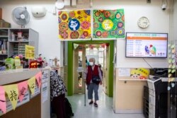 Seorang nenek setelah mendapatkan pelayanan pedikur dan manikur secara gratis di pusat komunitas lansia di Hong Kong sebagai bagian dari inisiatif amal, 8 November 2021. (Foto: AFP/Isaac Lawrence)