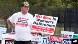 ARSIP - Seorang pria mendesak masyarakat untuk menentang Peraturan Persamaan Hak di luar tempat pemungutan suara di Houston, 21 Oktober 2015. Para pemilih menentang peraturan tersebut ketika para penentang mengkampanyekan pesan “Tidak boleh ada pria di kamar mandi wanita.” (foto: AP Photo/Pat Sullivan)