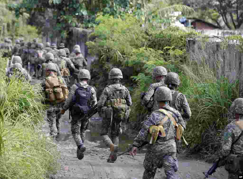 Philippine marines move to another location to engage Muslim rebels who are holding scores of hostages being used as human shields for the fourth day, Zamboanga, Philippines, Sept. 12, 2013.