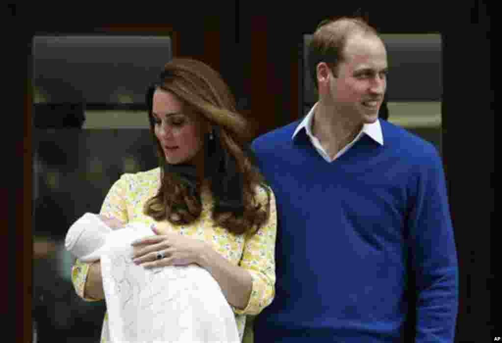 Britain's Prince William, right, and Kate, Duchess of Cambridge, pose for the media with their newborn daughter outside St. Mary's Hospital's exclusive Lindo Wing, London, Saturday, May 2, 2015. The Duchess gave birth to the Princess on Saturday morning.