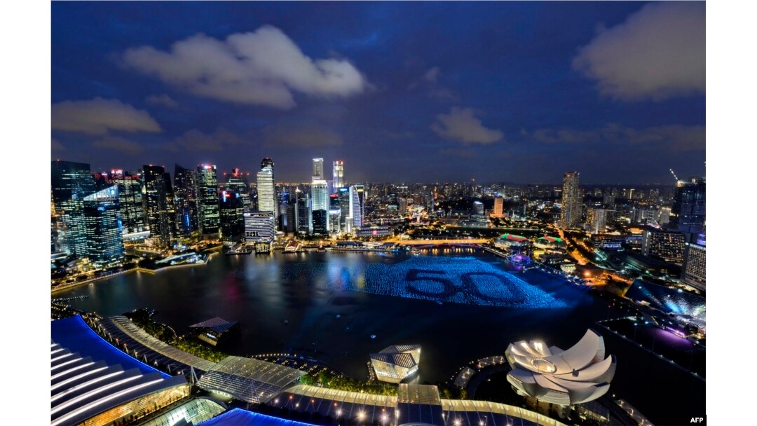 Singapore's skyline gliters with lights as spheres in the waters of Marina Bay form the number '50' to mark Singapore’s 50th anniversary in 2015. AFP PHOTO / MOHD FYROL