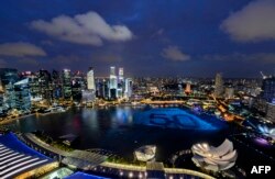 Singapore's skyline gliters with lights as spheres in the waters of Marina Bay form the number '50' to mark Singapore’s 50th anniversary in 2015. AFP PHOTO / MOHD FYROL