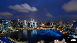 Singapore's skyline glitters with lights as spheres in the waters of Marina Bay form the number '50' to mark Singapore’s 50th anniversary in 2015, ahead of the New Year's countdown celebrations in Singapore on December 31, 2014. The city is the most expensive place on earth to rent an apartment. AFP PHOTO / MOHD FYROL