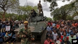 FILE: Army soldiers stand guard as protesters demanding President Robert Mugabe stands down gather on the road leading to State House in Harare, Zimbabwe Saturday, Nov. 18, 2017. (AP Photo/Ben Curtis)