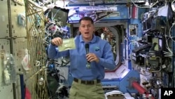 In this image taken from NASA video recorded Nov. 18, 2016, NASA astronaut Shane Kimbrough shows a pouch of turkey he will be preparing Thursday for the crew in celebration of the Thanksgiving holiday aboard the International Space Station.