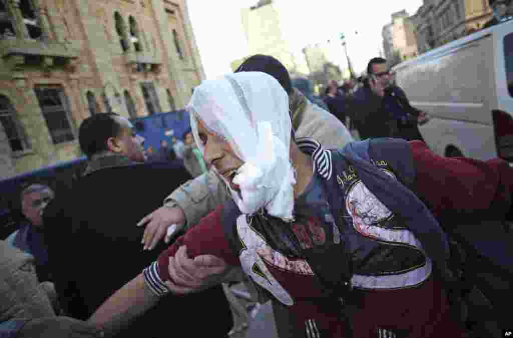 یک مجروح بمبگذاری در ستاد فرماندهی پلیس در مرکز شهر به آمبولانس حمل می شود. بیشتر کشته ها و مجروحین مأموران پلیس و امنیتی بودند. قاهره، ۲۴ ژانویه
