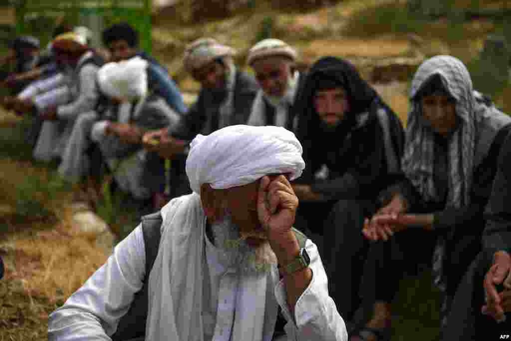 A mourner reacts as he attends a burial ceremony of the victims who died in the flash flood that affected the area, at a cemetery near Sayrah-e-Hopiyan in Charikar, Parwan province, Afghanistan.