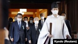 Seorang pendeta Shinto menemani sekelompok anggota parlemen Jepang saat mereka mengunjungi kuil Yasukuni untuk memberi penghormatan kepada korban perang negara itu di Tokyo, Jepang, 7 Desember 2021. (Kyodo/via REUTERS)