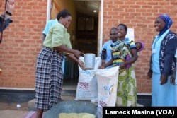 Women receive their share of 4.5 kilograms of soya flour at Mbela Health Center in Balaka distrcit, Malawi, under the WFP funded Supplementary Feeding Program.