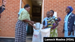 Des femmes reçoivent 4.5 kg de farine de soja au centre médicale Mbela dans le district de Balaka au Malawi. Programme alimentaire mondial
