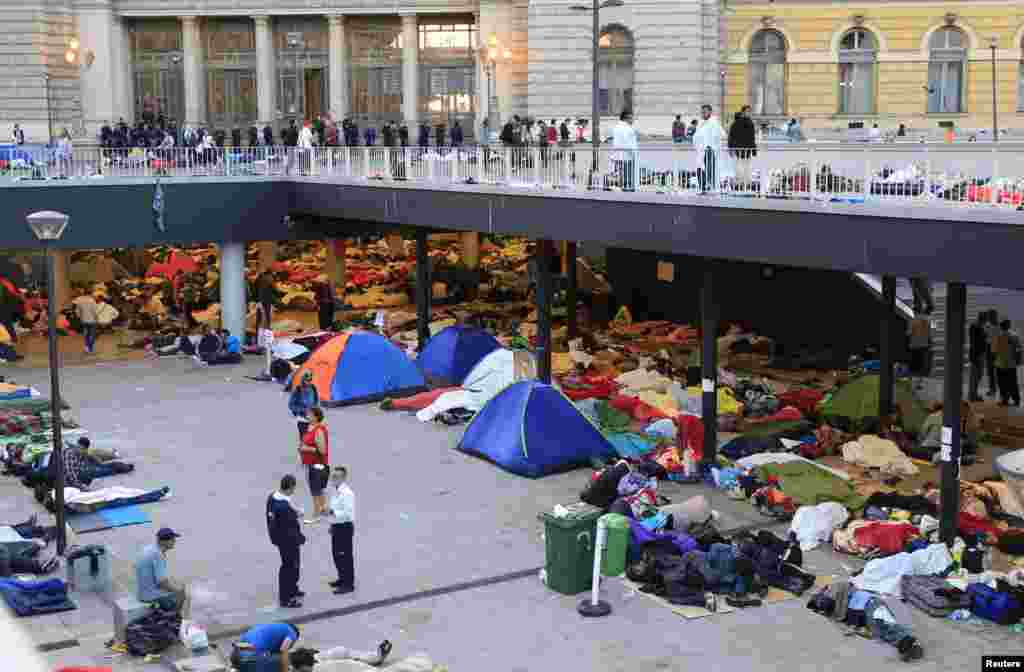 Para migran tidur di luar stasiun kereta Keleti di Budapest, Hungaria (3/9). Lebih dari 2.000 migran, banyak diantaranya pengungsi dari konflik-konflik di Timur Tengah dan Afrika, telah berkemah di depan stasiun tersebut, yang ditutup untuk mereka oleh pihak berwenang karena aturan Uni Eropa yang melarang orang-orang dengan dokumen sah untuk bepergian. (Reuters/Bernadett Szabo)