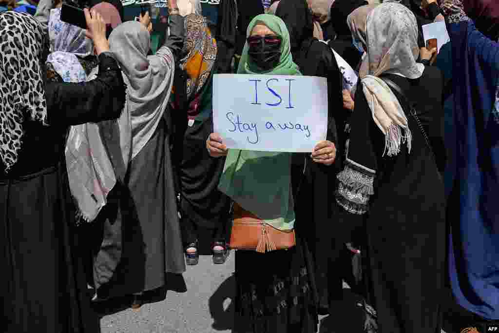 مظاہرے میں شریک ایک خاتون نے پلے کارڈ اٹھا رکھا ہے جس پر پاکستان کے خفیہ ادارے انٹر سروس انٹیلی جنس (آئی ایس آئی) تحریر ہے۔
