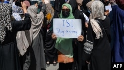 منگل کو پاکستانی سفارت خانے کے باہر ہونے والے مظاہرے میں ایک خاتون نے پاکستان مخالف پوسٹر اُٹھا رکھا ہے۔ 