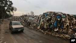 A car passes by a pile of garbage in Karantina, east Beirut, Lebanon, Dec. 17, 2015.
