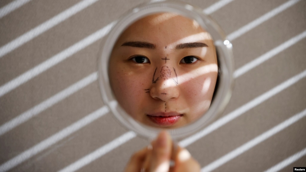 FILE - Ryu Han-na poses for photographs before undergoing nose plastic surgery at WooAhIn Plastic Surgery Clinic in Seoul, South Korea, December 17, 2020. (REUTERS/Kim Hong-Ji)