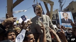Anti-government protestors react and shout slogans with an effigy of Yemeni President Ali Abdullah Saleh hanging during a demonstration demanding his resignation in Sanaa, Yemen, October 15, 2011.