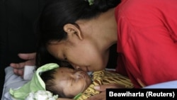 Seorang ibu Indonesia mencium bayinya yang berusia satu bulan setelah dirawat di sebuah rumah sakit di Yogyakarta 28 Mei 2006. Dampak pandemi Covid-19 ikut berdampak pada penurunan capaian temuan pneumonia pada balita di Indonesia. (Foto: Reuters/Beawiharta)