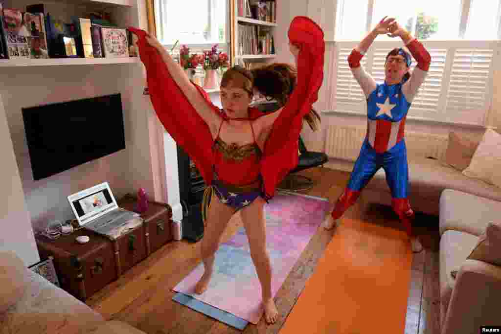 Dressed as superheroes, Jo Proudlove and daughter Eve, 9, follow the daily online &quot;PE with Joe&quot; Joe Wickes&#39; exercise class on &quot;Fancy dress Friday,&quot; at home in London, as the spread of the coronavirus disease (COVID-19) continues.