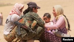 Kurd askari iroqlik qochqinlar bilan gaplashayapti. 