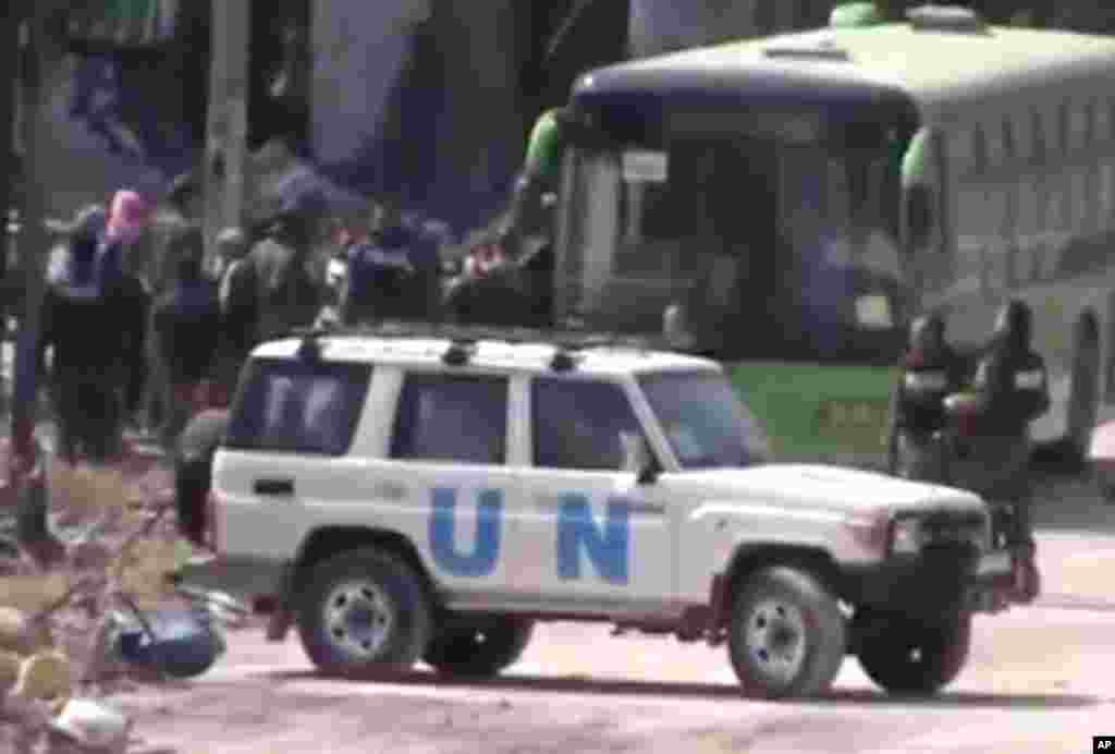 This scene from amateur video shows Syrian rebels boarding a bus leaving Homs, May 7, 2014.