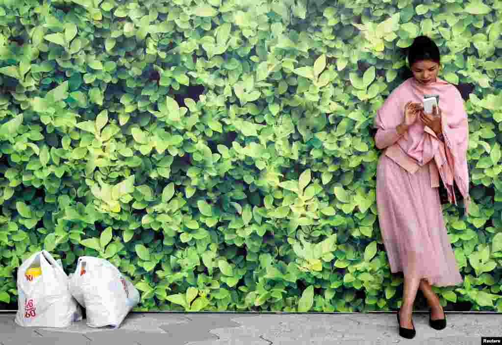 A woman uses her mobile at Tsim Sha Tsui waterfront in Hong Kong, China.