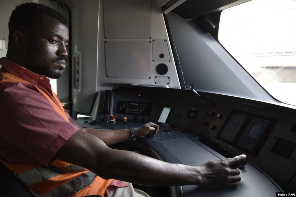 Momar Diop Sidibe, un conducteur de train, est assis dans la cabine du train à Dakar le 22 décembre 2021.