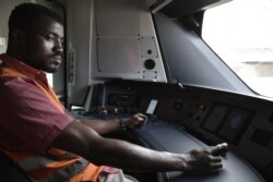 Momar Diop Sidibe, un conducteur de train, est assis dans la cabine du train à Dakar le 22 décembre 2021.