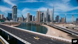 Sebuah taksi tampak melintas di jalan raya yang biasanya macet dekat Burj Khalifa, gedung tertinggi di dunia, di Dubai, Uni Emirat Arab, Senin, 6 April 2020. (Foto: dok)