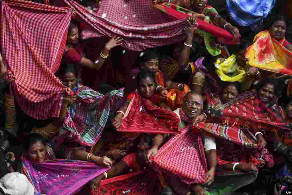 인도 콜카타 마단모한 힌두사원에서 열린 &#39;안나쿠트&#39; 축제 참가자들이 공물로 바쳐진 행운의 쌀을 받기 위해 보자기를 펼치고 있다.