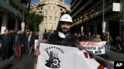 A protester from the Public Power Corporation union marches during an anti-austerity rally, in central Athens, Greece, during a 24-hour strike, Dec. 14, 2017.