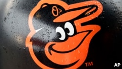 FILE - Rain drops stick to a Baltimore Orioles logo before the team's home opener against the Toronto Blue Jays, April 10, 2015.