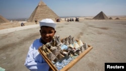 A child vendor waits for tourists to sell them souvenirs at the Giza Pyramids, on the outskirts of Cairo, August 26, 2013.