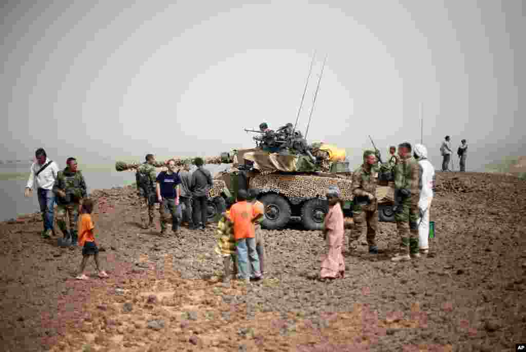 Des habitants de Gao et des journalistes rassembl&eacute;s pr&egrave;s d&#39;un char Sagay positionn&eacute; pr&egrave;s du pont sur le Niger, &agrave; l&#39;entr&eacute;e de Gao.