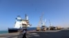 FILE - A coastguard walks past a ship docked at the Red Sea port of Hodeida, Yemen, Jan. 5, 2019. 