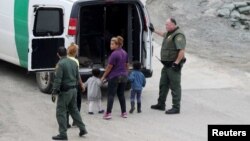 지난해 12월 미 세관국경보호국 직원들이 불법으로 국경을 넘다 잡힌 여성과 아이들을 차로 인솔하고 있다. (자료사진)