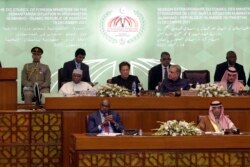Pakistan's Prime Minister Imran Khan, center, and Pakistani Foreign Minister Shah Mahmood Qureshi, center right, attend the extraordinary session of Organization of Islamic Cooperation (OIC) Council of Foreign Ministers, in Islamabad, Pakistan, Dec. 19, 2