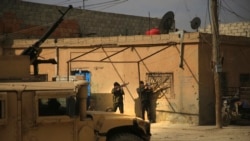 FILE - Kurdish-led Syrian Democratic Forces fighters take their positions at an alley near the al-Sina’a prison, in Hasakah, northeast Syria, Jan. 23, 2022.