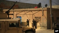 FILE - Kurdish-led Syrian Democratic Forces fighters take their positions at an alley near the al-Sina'a prison, in Hasakah, northeast Syria, Jan. 23, 2022.