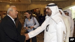 Ông Burhan Ghalioun (trái), lãnh đạo nhóm đối lập SNC, chào những người đến dự cuộc họp ở Doha