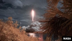 A SpaceX Falcon 9 rocket carrying the company's Crew Dragon spacecraft is seen in this false color infrared exposure as it is launched on NASA’s SpaceX Demo-2 mission to the International Space Station with NASA astronauts Robert Behnken and Douglas Hurle