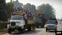 Một chiếc xe cảnh sát chạy ngang qua chiếc xe tải chở những người Hồi Giáo đang trên đường đến làng Bangui, 17/1/2014
