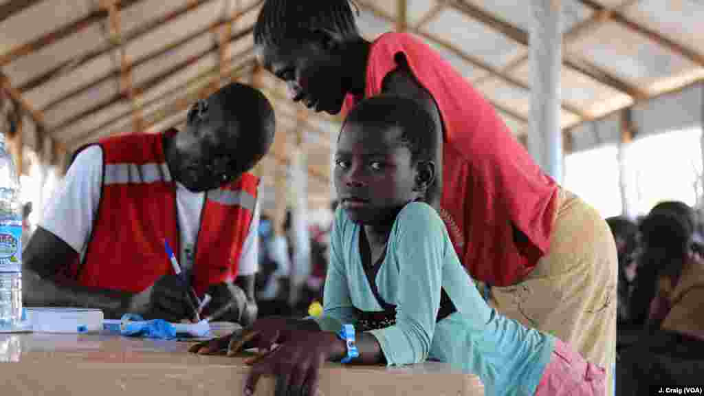 Une jeune fille sud-soudanaise attend que sa mère termine ses formalités dans un centre de traitement à Imvepi. le 31 mars 2017 à Arua, en Ouganda.