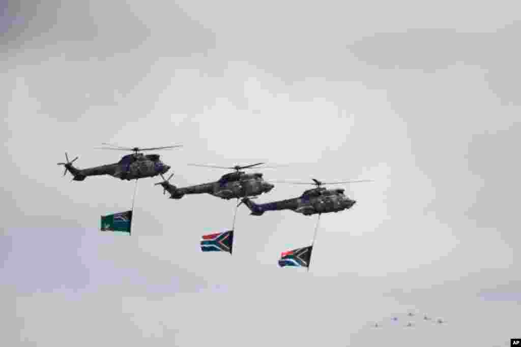 Three helicopters fly over the gravesite during the burial of Nelson Mandela in his hometown Qunu.